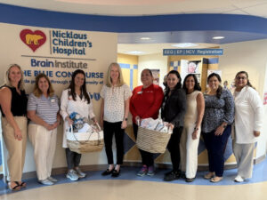 Catalyst employees posing with handmade stuffed animals for young patients at Nicklaus Children's Hospital.