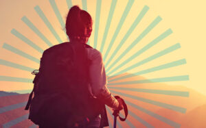 A hiker facing away, looking at a sunset