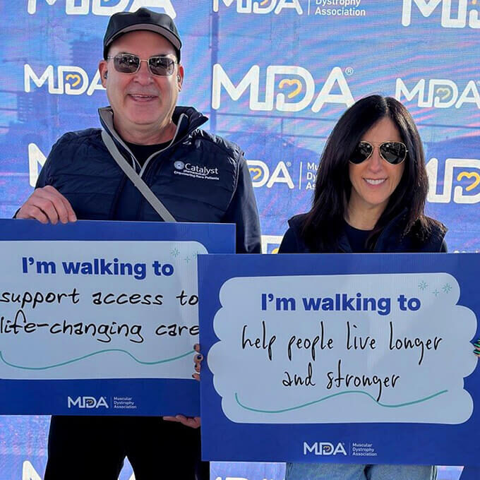 Catalyst employees posing with signs at a walk for the Muscular Dystrophy Association.
