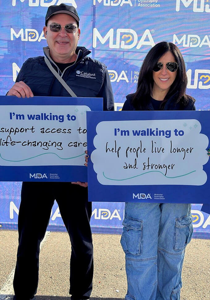 Catalyst employees posing with signs at a walk for the Muscular Dystrophy Association.